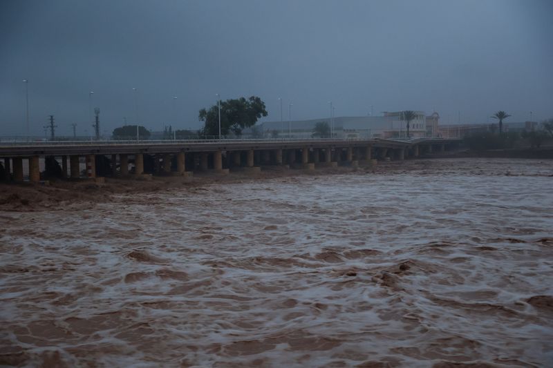 © Reuters. River water churns, with a partially collapsed bridge seen in the background, after torrential rains caused flooding in the town of Carlet, Valencia region, Spain, October 30, 2024. REUTERS/Eva Manez