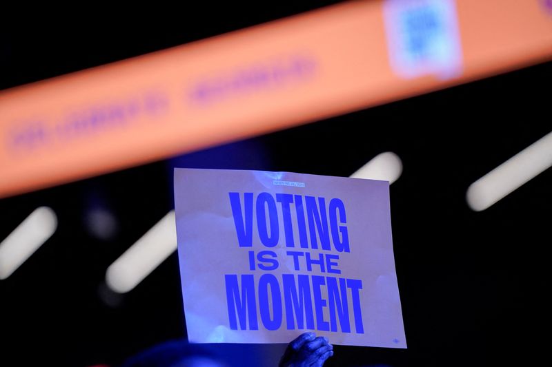 © Reuters. A supporter holds up a poster as Former U.S. first lady Michelle Obama hosts a rally for Democratic presidential nominee U.S. Vice President Kamala Harris at Gateway Center Arena in College Park, Georgia, U.S. October 29, 2024. REUTERS/Cheney Orr/File Photo