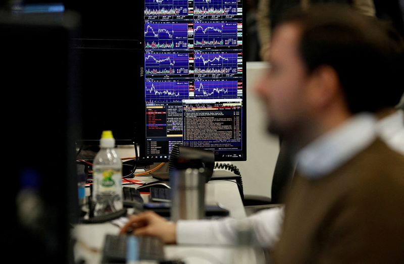 &copy; Reuters. FILE PHOTO: Financial traders work at their desks at CMC Markets in the City of London, Britain, April 11, 2019.  REUTERS/Peter Nicholls/File Photo