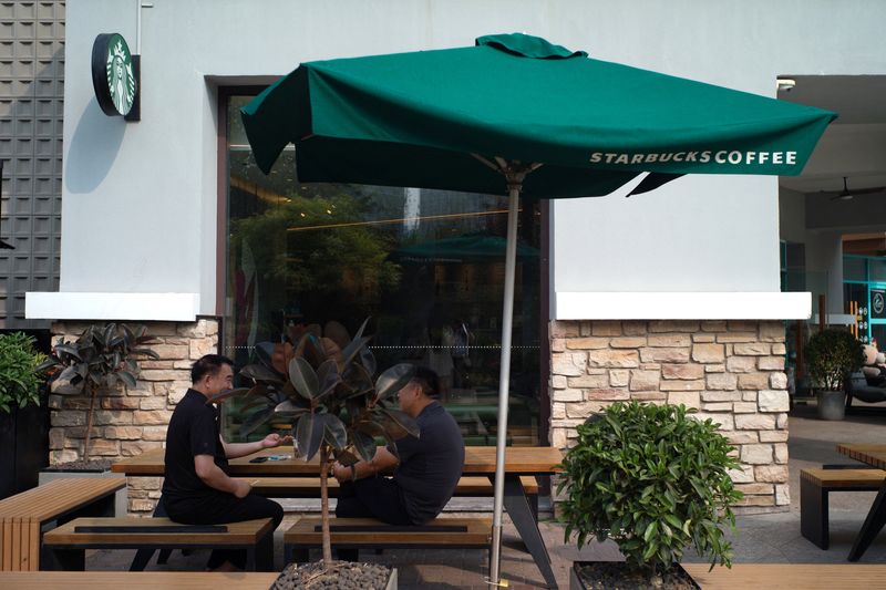 © Reuters. People sit outside a Starbucks coffee shop in Beijing, China, May 22, 2024. REUTERS/Tingshu Wang/File Photo