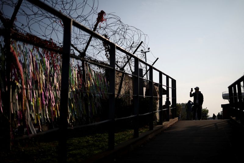 © Reuters. FILE PHOTO: A man takes photographs in front of a military fence near the demilitarized zone separating the two Koreas, in Paju, South Korea, October 31, 2024. REUTERS/Kim Hong-Ji/File Photo