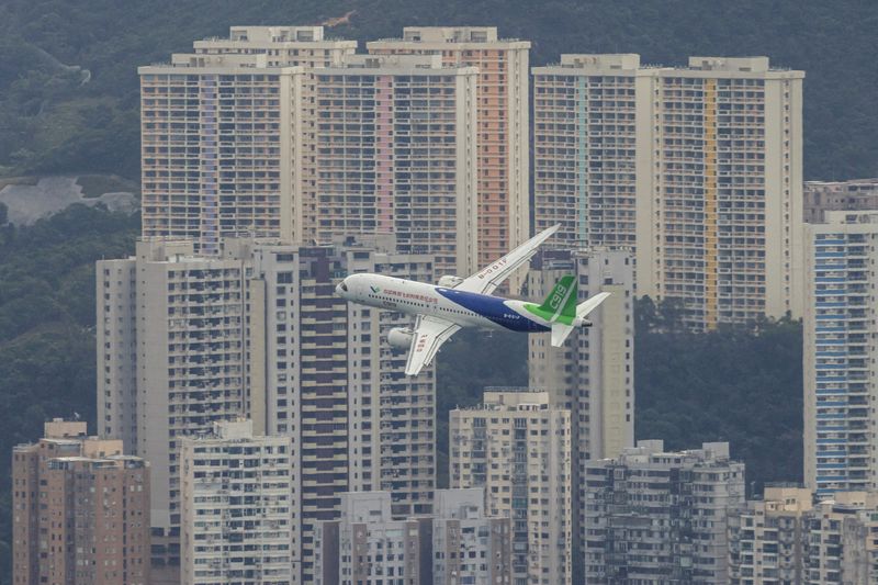 © Reuters. FILE PHOTO: China's first domestically manufactured passenger aircraft Comac C919 flies over Victoria Harbour during its inaugural voyage outside the mainland, in Hong Kong, China December 16, 2023. REUTERS/Tyrone Siu/File Photo