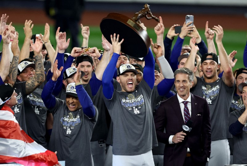 © Reuters. Oct 31, 2024; New York, New York, USA; Los Angeles Dodgers first baseman Freddie Freeman (5) accepts the Willie Mays World Series Most Valuable Player trophy after winning the 2024 MLB World Series against the New York Yankees at Yankee Stadium. Mandatory Credit: Vincent Carchietta-Imagn Images