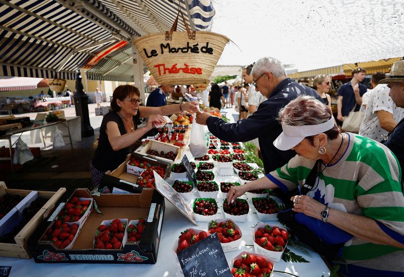 © Reuters. FILE PHOTO: Shoppers buy fruits at a local market in Nice, France, June 8, 2023. REUTERS/Eric Gaillard/File Photo