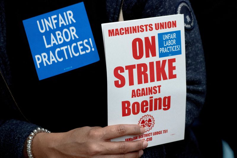 © Reuters. FILE PHOTO: A Boeing worker from the International Association of Machinists and Aerospace Workers District 751 holds a sign while attending a rally at their union hall during an ongoing strike in Seattle, Washington, U.S. October 15, 2024. REUTERS/David Ryder/File Photo