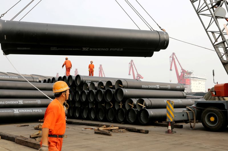 © Reuters. Workers direct a crane lifting ductile iron pipes for export at a port in Lianyungang, Jiangsu province, China June 30, 2019. REUTERS/ File Photo