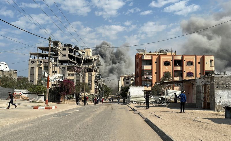 © Reuters. Palestinians watch as smoke rises following Israeli strikes, amid the ongoing conflict between Israel and Hamas, in Nuseirat in the central Gaza Strip, November 1, 2024. REUTERS/Khamis Said