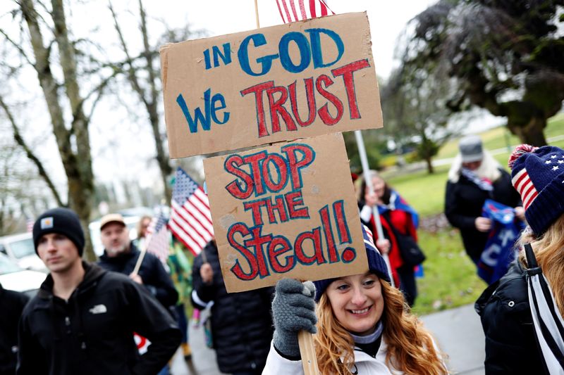 © Reuters. FILE PHOTO: A protester holds signs saying 