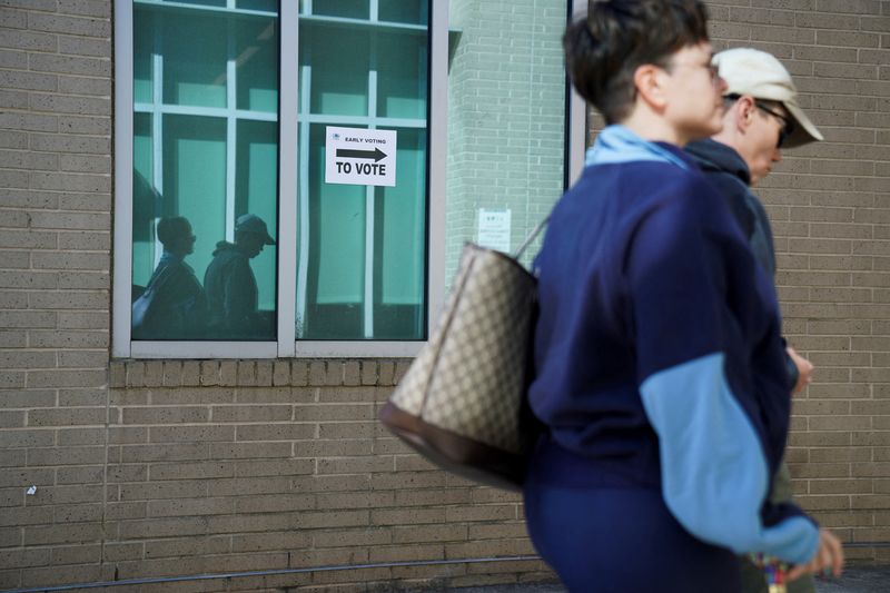 © Reuters. FILE PHOTO: Voters walk to a polling station, as Georgians turned out a day after the battleground state opened early voting, in Atlanta, Georgia, U.S., October 16, 2024. REUTERS/Megan Varner/File Photo