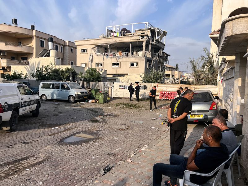 © Reuters. Residents and police officials gather near a house that was hit, following a projectiles attack from Lebanon towards Israel, amid cross-border hostilities between Hezbollah and Israel, in the central Israeli town of Tira, November 2, 2024. REUTERS/Rami Amichay