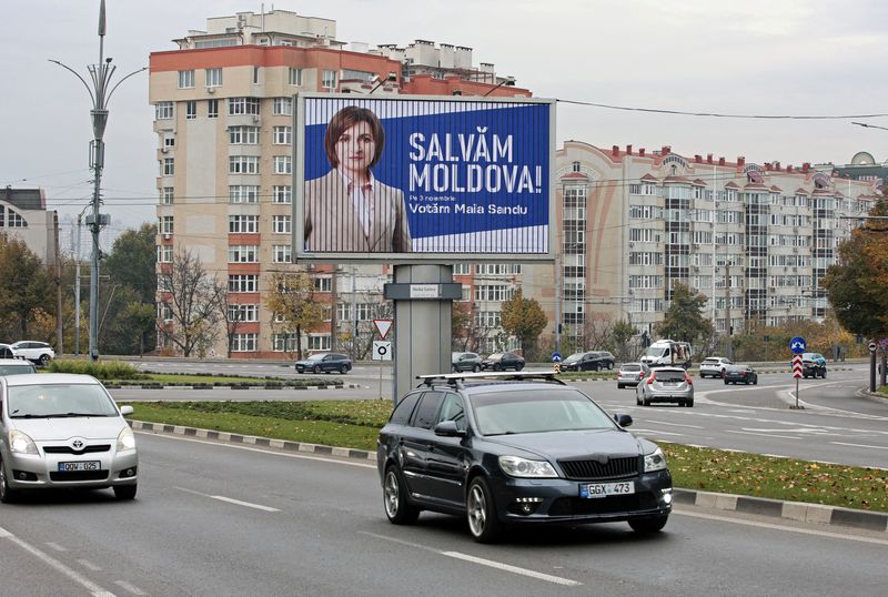 © Reuters. FILE PHOTO: Cars drive past an election banner of Moldova's incumbent President and presidential candidate Maia Sandu in Chisinau, Moldova October 30, 2024. REUTERS/Vladislav Culiomza/File Photo