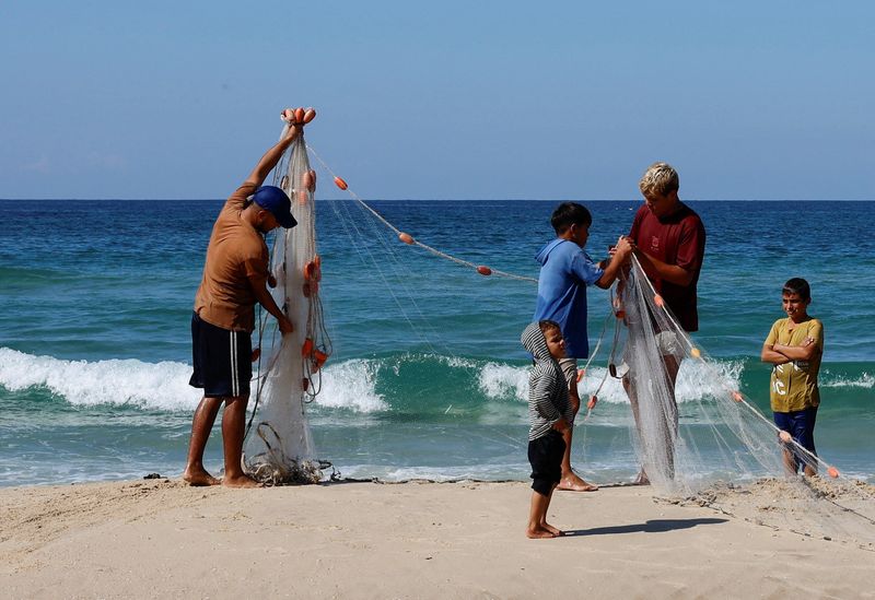 &copy; Reuters. Palestinian fishermen work, during the ongoing conflict between Israel and Hamas, along the coast of Khan Younis, in the southern Gaza Strip, November 1, 2024. REUTERS/Mohammed Salem