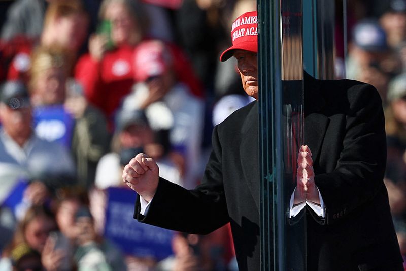 © Reuters. Republican presidential nominee and former U.S. President Donald Trump gestures while touching the protective glass, during a campaign rally, in Lititz, Pennsylvania, U.S. November 3, 2024. REUTERS/Eloisa Lopez