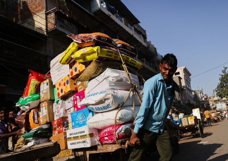 © Reuters. A labourer reacts as he transports a cart full of sacks at a wholesale market in the old quarters of Delhi, India, June 7, 2023. REUTERS/Anushree Fadnavis/ File Photo