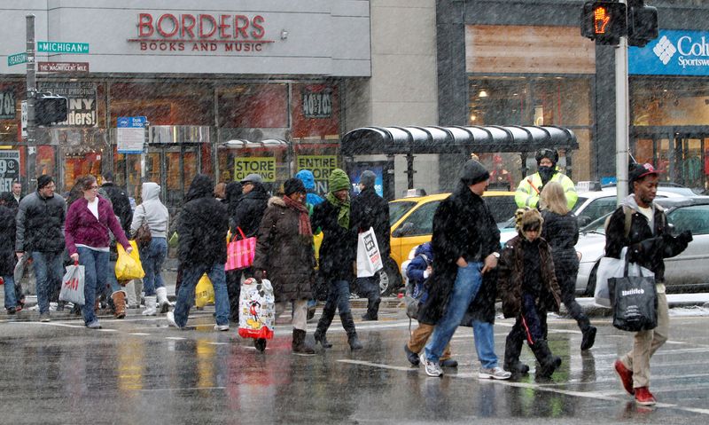 © Reuters. FILE PHOTO: Holiday shoppers carry their packages, as they walk down Michigan Avenue, during heavy snowfall, in Chicago December 24, 2010. REUTERS/Frank Polich/File Photo