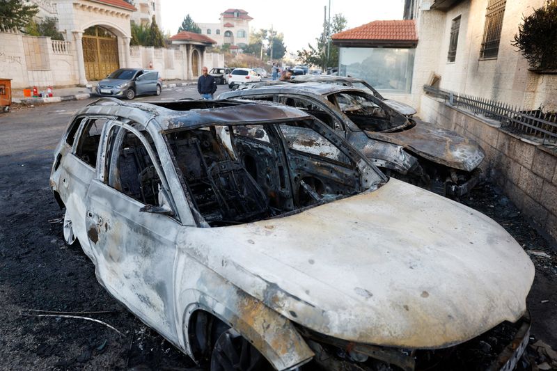 &copy; Reuters. Palestinians look at a damaged cars after an Israeli settlers attack in Al-Bireh city, in the Israeli-occupied West Bank, November 4, 2024. REUTERS/Mohammed Torokman