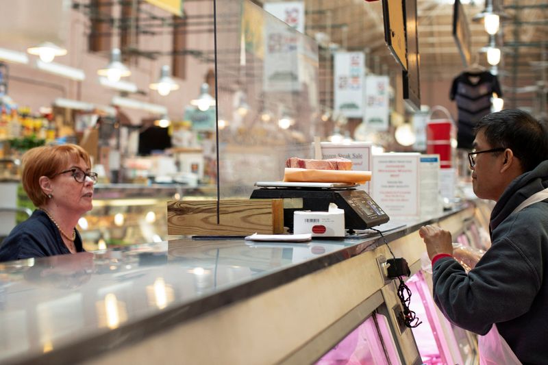 © Reuters. FILE PHOTO: A woman purchases meat from a butcher at Eastern Market in Washington, U.S., August 14, 2024. REUTERS/Kaylee Greenlee Beal/File photo