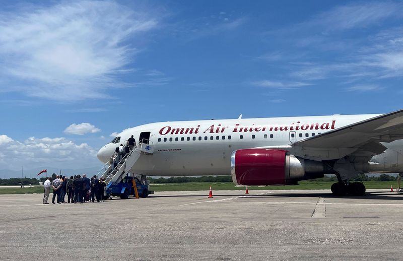 © Reuters. FILE PHOTO: People board a Boeing 767 plane operated by U.S. charter airline Omni Air International in Port-au-Prince, Haiti August 31, 2023. REUTERS/Ralph Tedy Erol/File Photo