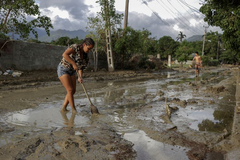 &copy; Reuters. FILE PHOTO: People try to remove mud from a street a week after Hurricane Oscar hit the town of Imias in Guantanamo province, Cuba, Oct. 29, 2024. Ariel Ley/Pool via REUTERS/File Photo