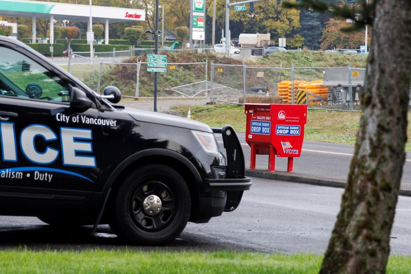 &copy; Reuters. FILE PHOTO: Officer Tyler Knott of the Vancouver Police Department surveils ballot boxes, where a freshly replaced ballot box stands in the Fisher's Landing Transit Center, following what police believe were three arsons at ballot drop boxes in the northw