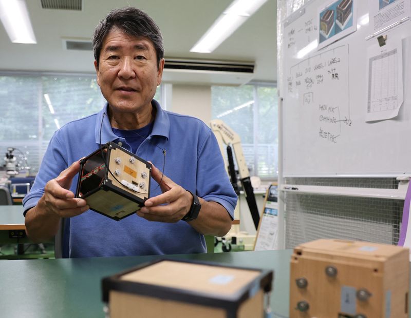 © Reuters. FILE PHOTO: Takao Doi, a former Japanese astronaut and professor at Kyoto University, holds an engineering model of LignoSat during an interview with Reuters at his laboratory at Kyoto University in Kyoto, Japan, October 25, 2024. REUTERS/Irene Wang/File Photo