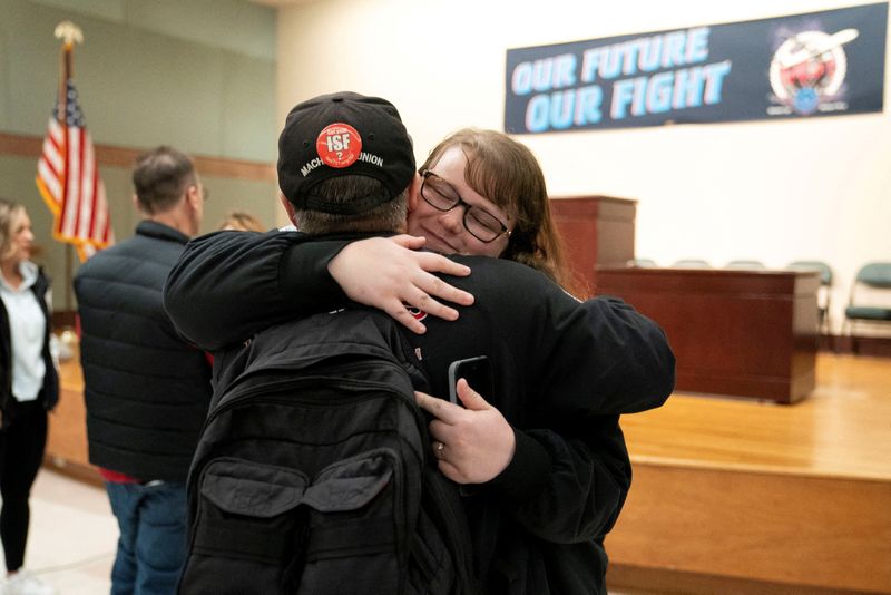 © Reuters. Members of the International Association of Machinists and Aerospace Workers District 751, embrace at a union hall after learning that union members voted to approve a new contract proposal from Boeing in Seattle, Washington, U.S. November 4, 2024. REUTERS/David Ryder    