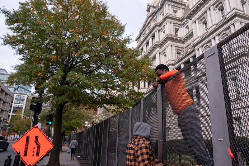 © Reuters. Workers erect security fencing near the White House ahead of the U.S. presidential election in Washington, U.S., November 4, 2024. REUTERS/Nathan Howard