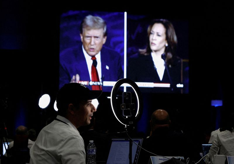 &copy; Reuters. FILE PHOTO: Members of the media use a screen to watch the presidential debate, as Republican presidential nominee, former U.S. President Donald Trump and Democratic presidential nominee, U.S. Vice President Kamala Harris attend a presidential debate host