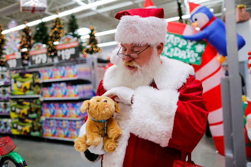 © Reuters. A man dressed as Santa Claus pets a toy as products are display for Christmas season at a Walmart store in Teterboro, New Jersey, U.S., October 26, 2016. REUTERS/Eduardo Munoz/File Photo