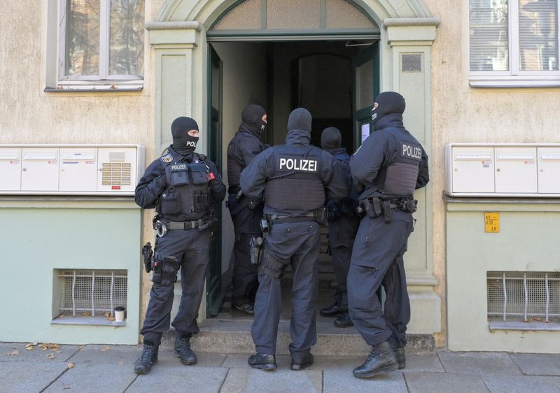 © Reuters. Masked German police officers guard a house after having arrested eight suspected members of a right-wing militant group driven by racist ideology and conspiracy theories who had been training in warfare for the downfall of the modern German state, in Dresden, Germany, November 5, 2024.   REUTERS/Matthias Rietschel