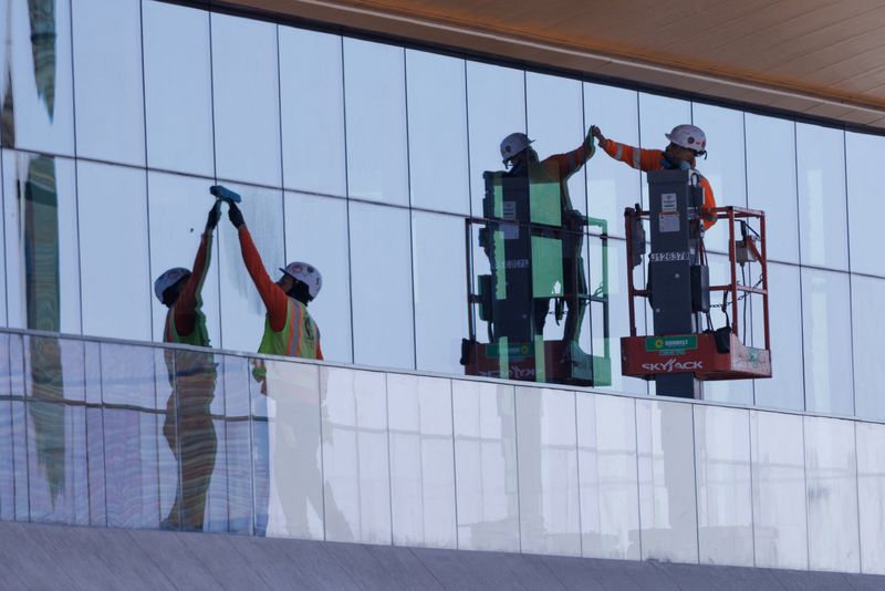 © Reuters. FILE PHOTO: Construction workers install windows on a nearly completed office building in San Diego, California, U.S., October 9, 2024. REUTERS/Mike Blake/File Photo