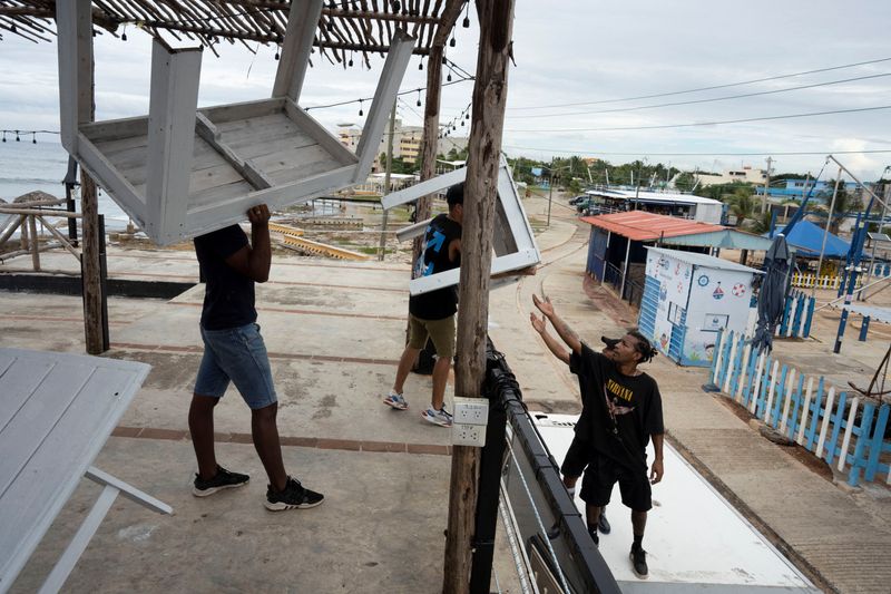 © Reuters. People relocate furniture from a restaurant prior to the arrival of Tropical Storm Rafael in Havana, Cuba, November 5, 2024. REUTERS/Alexandre Meneghini