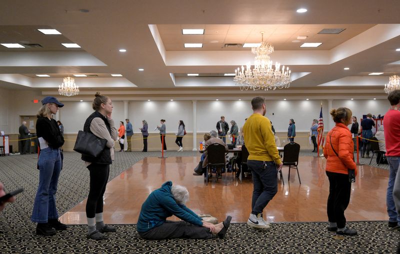 &copy; Reuters. A woman sits and stretches as she waits to vote as the Italian Heritage Center has had a line over an hour long since 7 am in Maine's 2nd congressional district during the 2024 U.S. presidential election on Election Day  in Portland, Maine, U.S., November