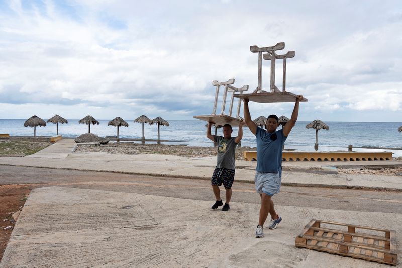 &copy; Reuters. Men relocate furniture from a restaurant prior to the arrival of Tropical Storm Rafael in Havana, Cuba, November 5, 2024. REUTERS/Alexandre Meneghini