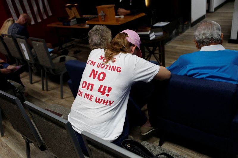 &copy; Reuters. Ashley Urban, wearing a 'Vote No' on Florida Amendment 4 shirt, which addresses the state’s abortion bill, prays with other parishioners for an ‘Election Eve Service of Prayer,’ in support of Republican Presidential nominee and former U.S. President