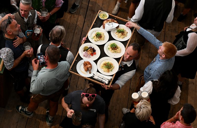 © Reuters. FILE PHOTO: A waiter carries food on the day of the official opening of the 189th Oktoberfest, the world's largest beer festival in Munich, Germany, September 21, 2024. REUTERS/Angelika Warmuth/File Photo