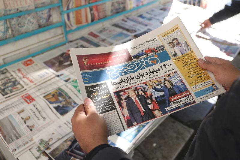 &copy; Reuters. An Iranian man looks at a newspaper with a picture of Republican presidential nominee and former U.S. President Donald Trump and Democratic presidential nominee U.S. Vice President Kamala Harris, in Tehran, Iran November 6, 2024. Majid Asgaripour/WANA (We