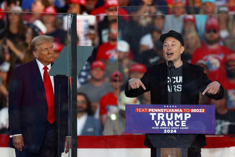 © Reuters. Tesla CEO and X owner Elon Musk speaks as Republican presidential nominee and former U.S. president Donald Trump looks on during a rally at the site of the July assassination attempt against Trump, in Butler, Pennsylvania, U.S., October 5, 2024. REUTERS/Carlos Barria/File Photo