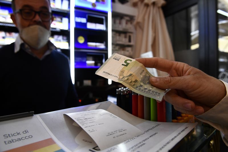 &copy; Reuters. Un uomo usa i contanti per pagare gli articoli durante lo shopping a Milano, Italia, 2 ottobre 2020. REUTERS/Flavio Lo Scalzo