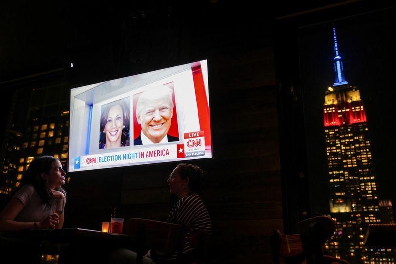 &copy; Reuters. Persone partecipano a un watch party al 230 Fifth Rooftop Bar, mentre sullo sfondo si vede l'Empire State Building, a New York City, Stati Uniti, il 5 novembre 2024. REUTERS/Andrew Kelly