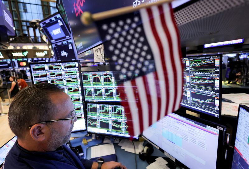 © Reuters. A trader works at the New York Stock Exchange (NYSE) next to a U.S. flag, after Republican Donald Trump won the U.S. presidential election, in New York City, U.S., November 6, 2024. REUTERS/Andrew Kelly