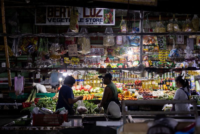 © Reuters. A vendor tends to a customer at a public market in Quezon City, Metro Manila, Philippines, October 4, 2024. REUTERS/Eloisa Lopez/ File Photo