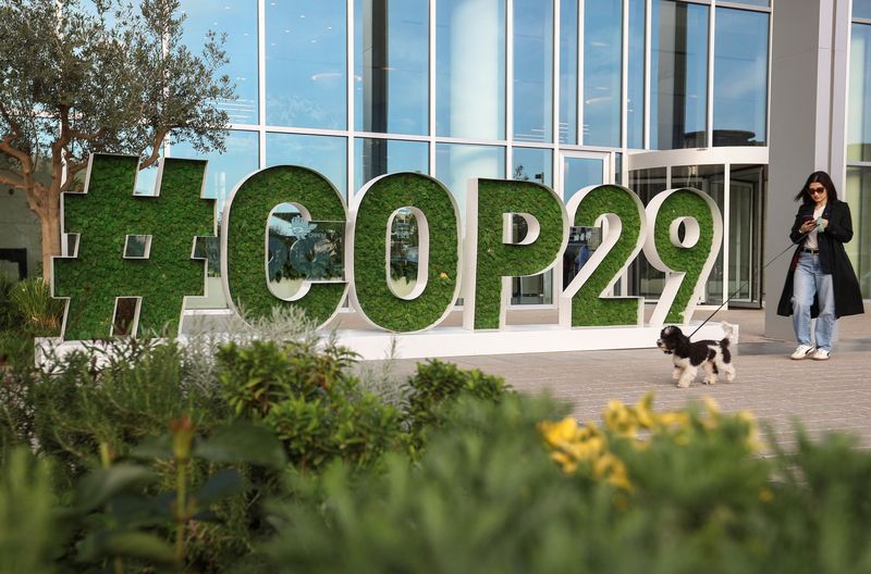 &copy; Reuters. FILE PHOTO: A woman walks past a sign of the COP29 United Nations Climate Change Conference, in Baku, Azerbaijan October 31, 2024. REUTERS/Aziz Karimov/File Photo