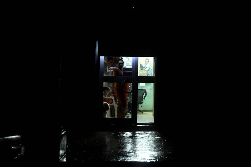 &copy; Reuters. A woman peers from a door as the energy grid suffers a complete blackout while Hurricane Rafael makes landfall in Artemisa province as a category three hurricane, in Havana, Cuba November 6, 2024. REUTERS/Norlys Perez