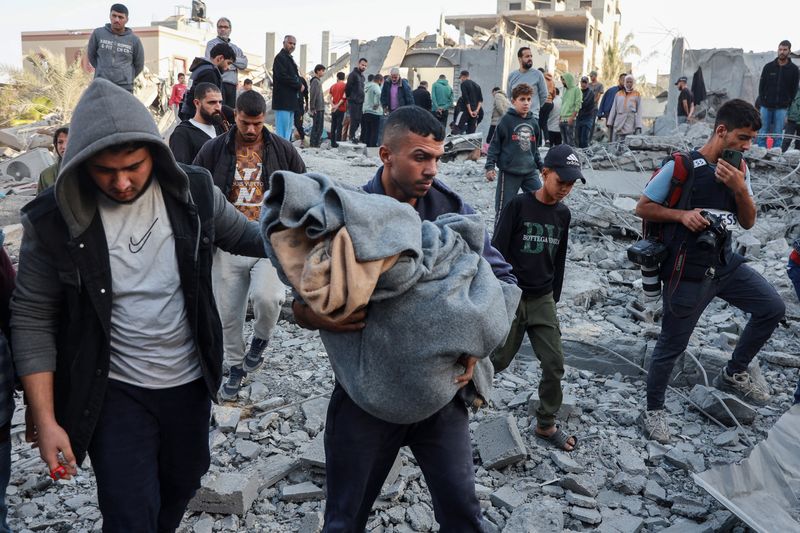 &copy; Reuters. A man carries the dead body of a Palestinian at the site of an Israeli strike on a house, amid the Israel-Hamas conflict, in Nuseirat in the central Gaza Strip November 7, 2024. REUTERS/Abd Elhkeem Khaled