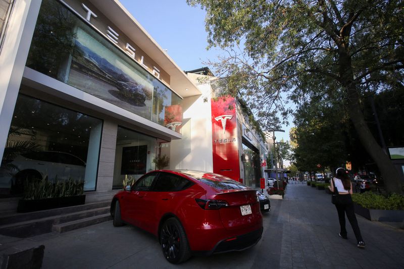 © Reuters. FILE PHOTO: A woman walks by a Tesla dealership in Mexico City, Mexico, March 3, 2023. REUTERS/Quetzalli Nicte-Ha/File Photo