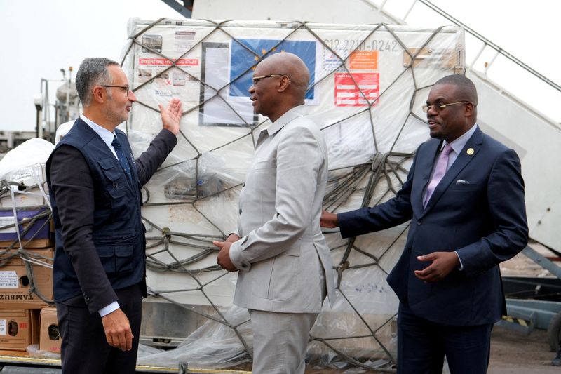 © Reuters. FILE PHOTO: Laurent Muschel, HERA Director General, presents mpox vaccines to the Democratic Republic of Congo's Health Minister Samuel Roger Kamba Mulamba as first batches arrive in the country, while Jean Kaseya, Africa CDC Director General, looks on, at N'Djili International Airport in Kinshasa, Democratic Republic of Congo September 5, 2024. REUTERS/Justin Makangara/File Photo