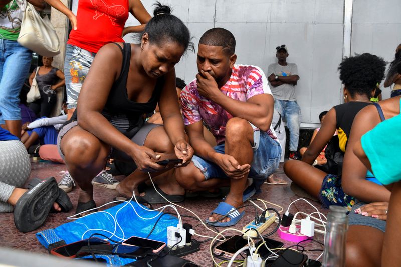 © Reuters. People charge their mobile phones after Hurricane Rafael knocked out the country's electrical grid, leaving 10 million people without electrical service, in Havana, Cuba November 7, 2024. REUTERS/Norlys Perez