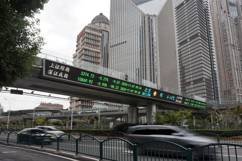 &copy; Reuters. FILE PHOTO: Cars travel past a pedestrian overpass with a display of stock information at the Lujiazui financial district in Shanghai, China, November 7, 2024. REUTERS/Nicoco Chan/File Photo