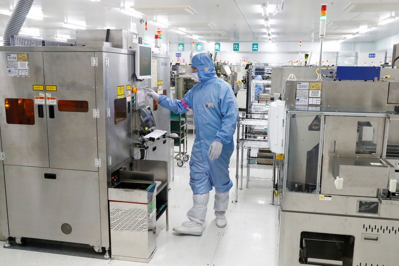 © Reuters. FILE PHOTO: A worker is seen at the factory of a semiconductor company in this file photo, in Beijing, China May 14, 2020. REUTERS/Thomas Peter/File Photo